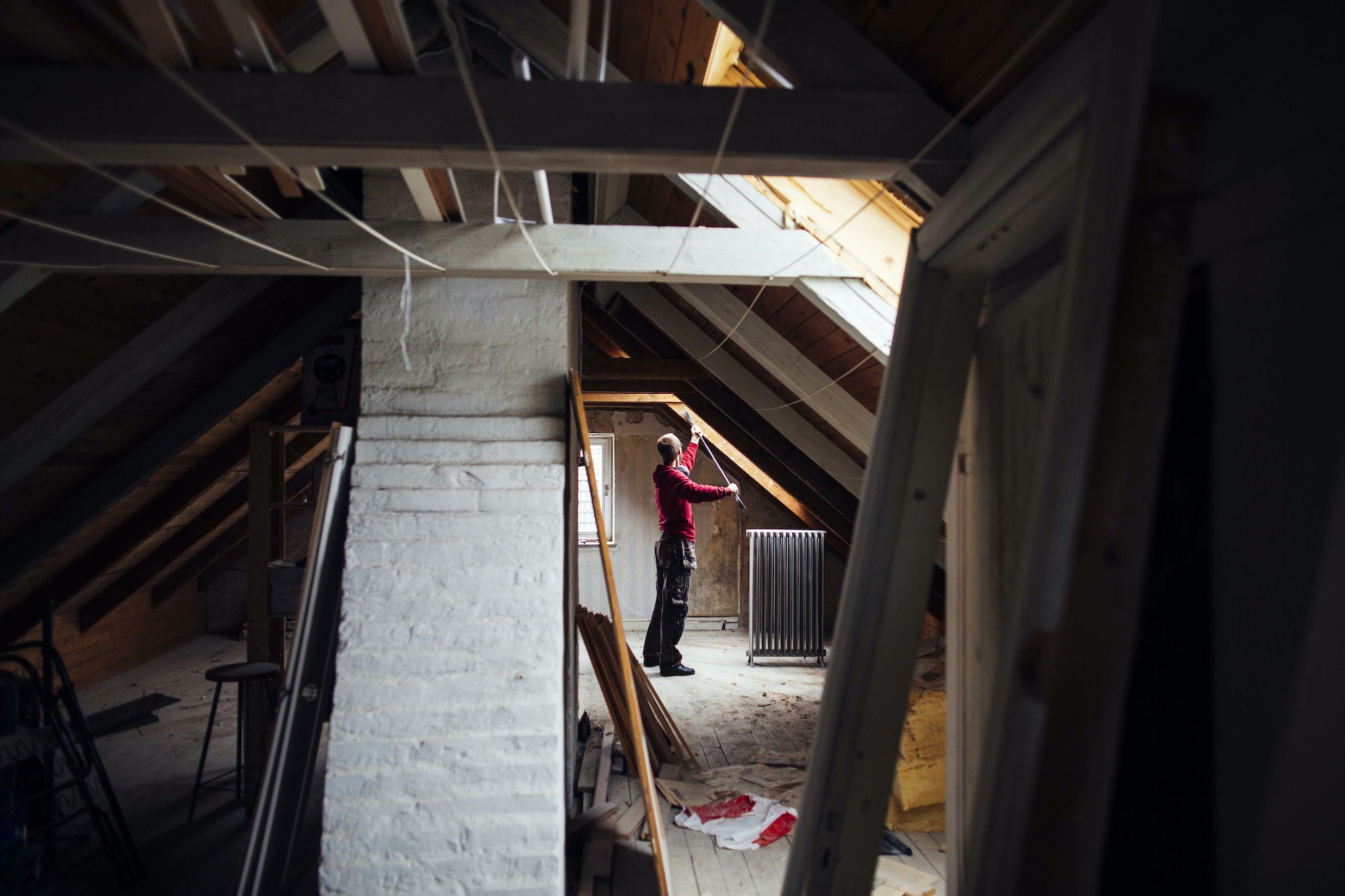 Side view of man working in attic under construction